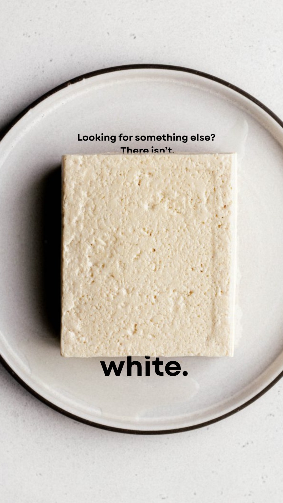 A plain block of fresh white paneer on a ceramic plate